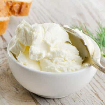 Cream cheese in a bowl with a spoon.