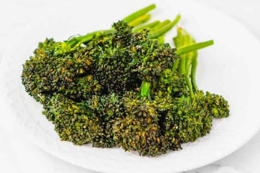 crispy air fryer broccolini on a white plate. 