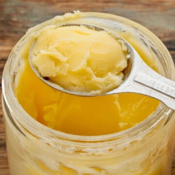 Scooping out desi ghee from a jar.