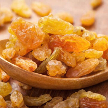 Raisins on a wooden spoon.