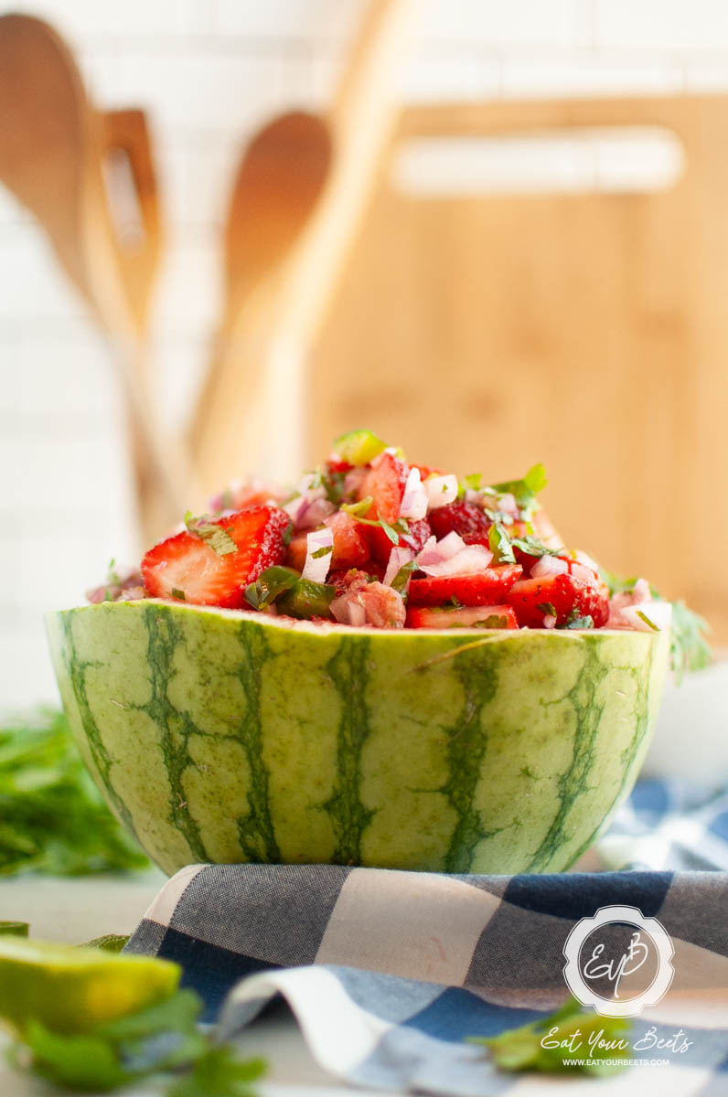 Strawberry jalapeno salsa in a watermelon bowl and chips on the side.