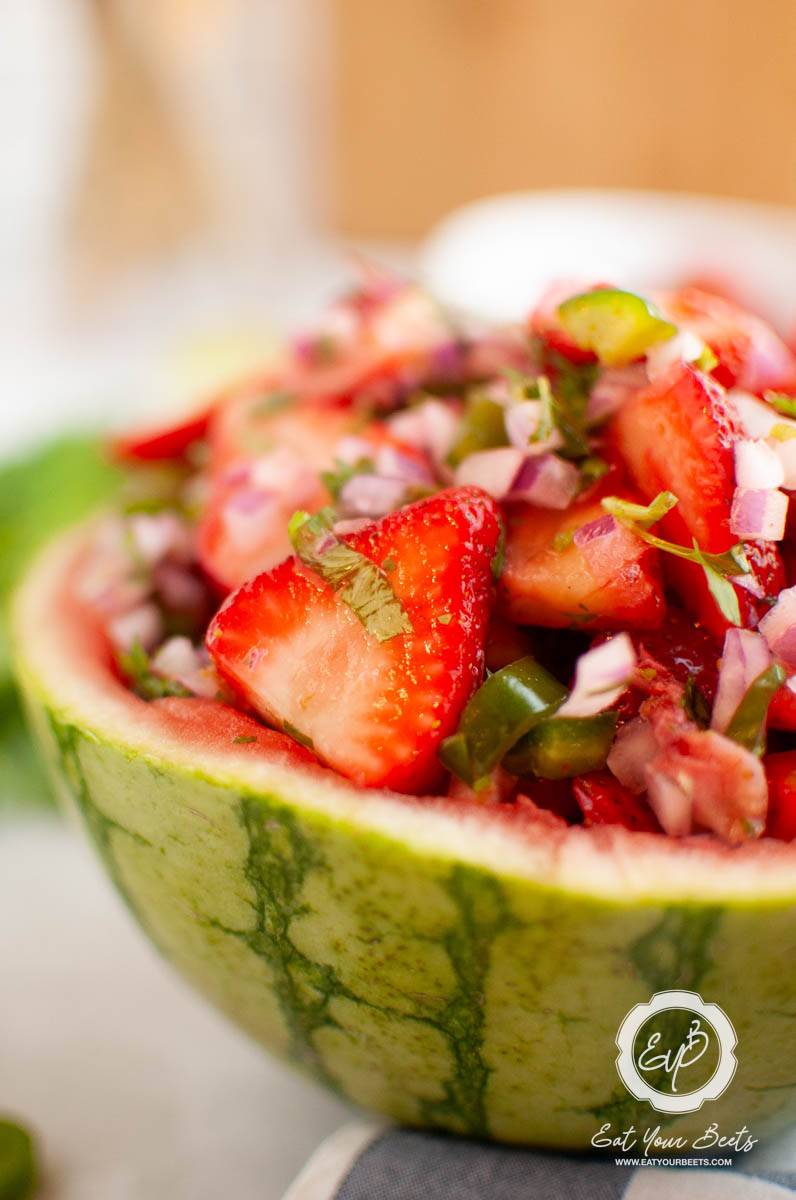 Strawberry jalapeno salsa in a watermelon bowl and chips on the side.
