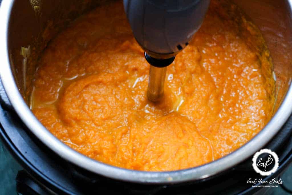Blending carrots and leaks mixture cooked in chicken broth.
