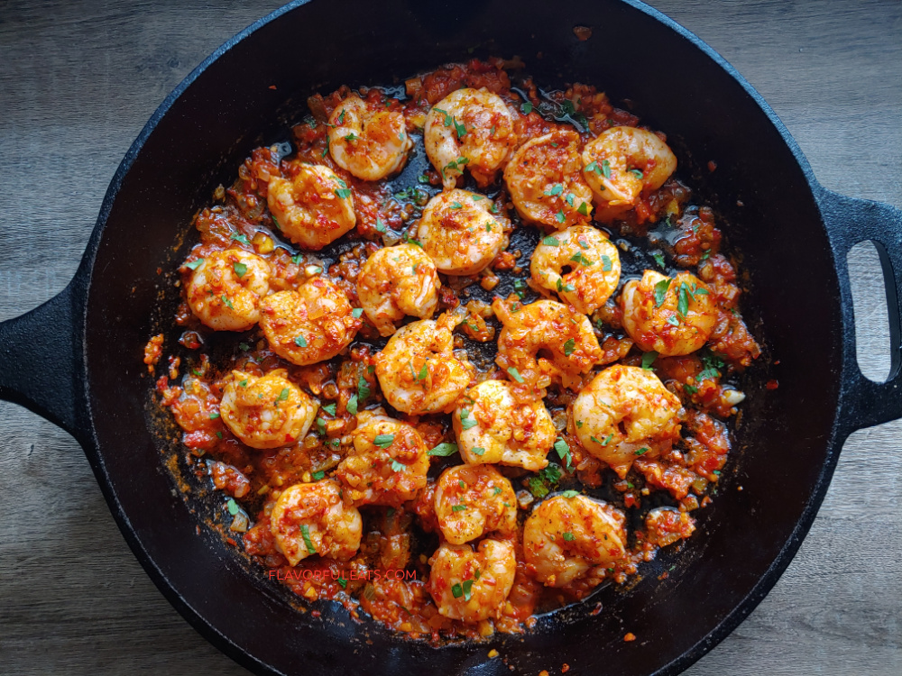 Harissa shrimps in a skillet.