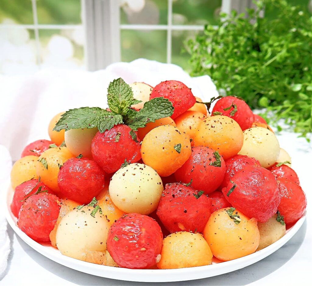 Watermelon balls in lime sauce on a plate.