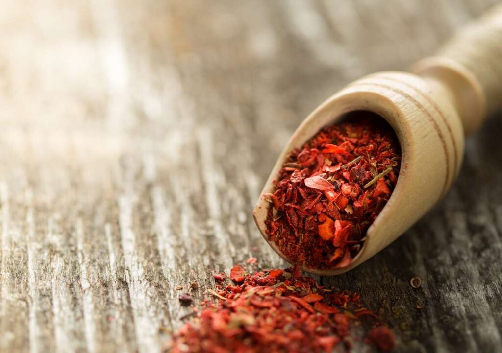 Dried tomato powder in a wooden spoon