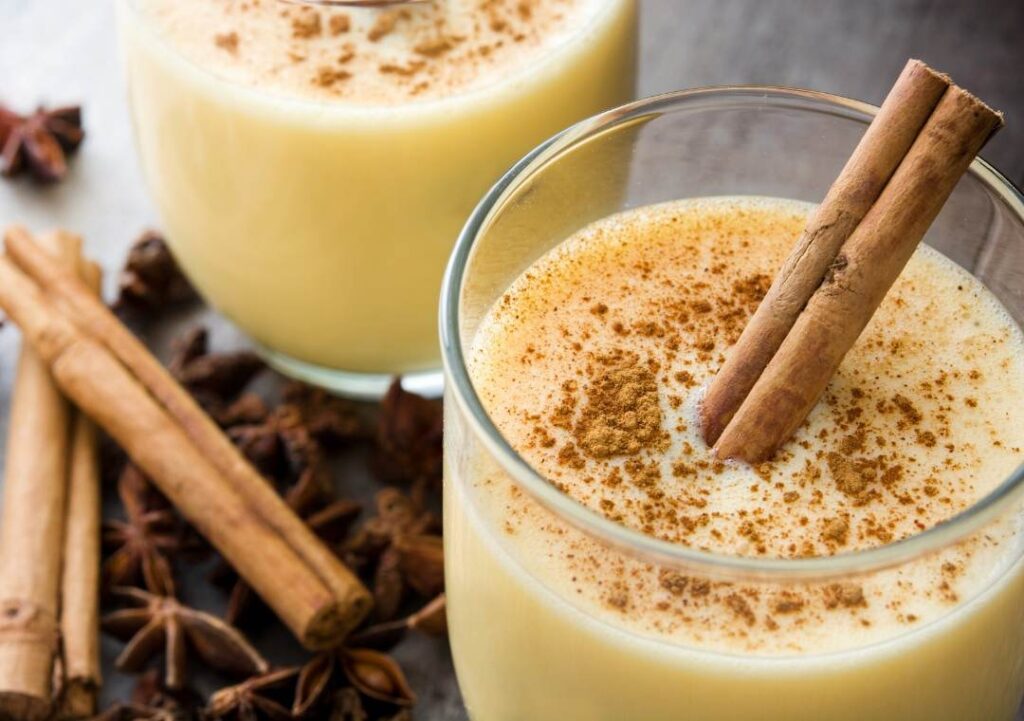 Can You Freeze Eggnog? eggnog in a glass with a cinnamon stick.