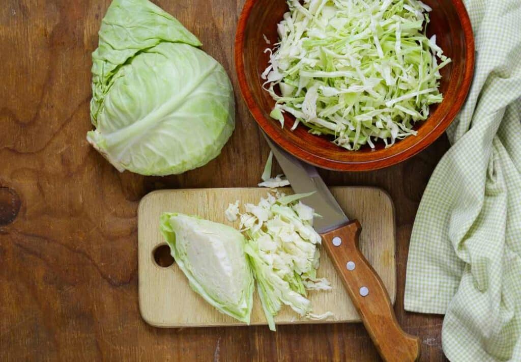 shredded cabbage in a bowl and on a chopping board ready for freezing.