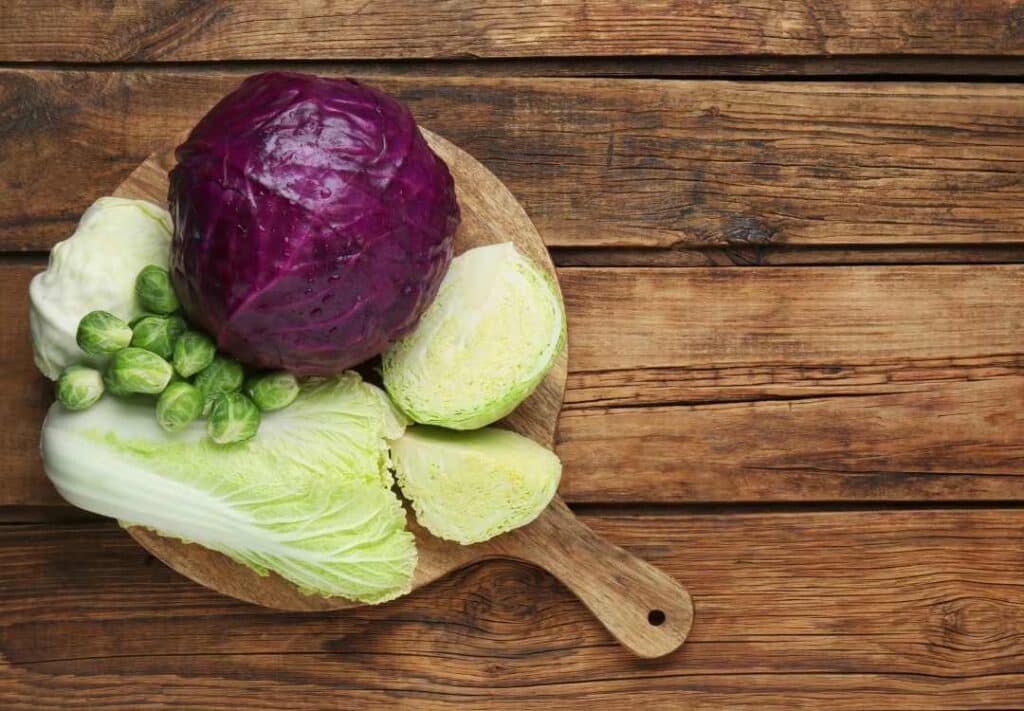Purple and Green Cabbage on a wooden chopping board.