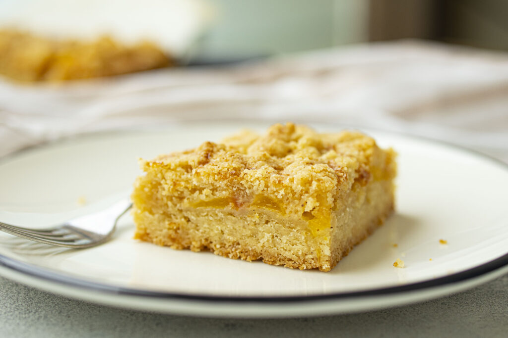 Baked peach pie bar on a plate.