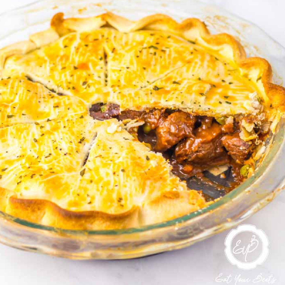 Hearty Beef Pot Pie With Celery And Carrots and s lice of pie cut out. 