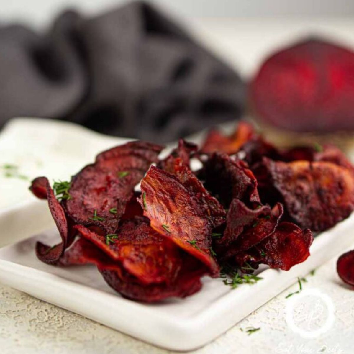 Crispy Air Fryer Beet Chips on w white plate. 