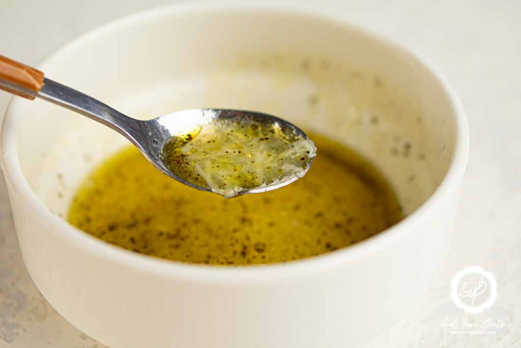 Mixing oil, salt, pepper, lemon juice, and garlic into small bow.