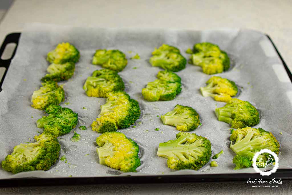 Seasoned broccoli pieces ready to be baked.