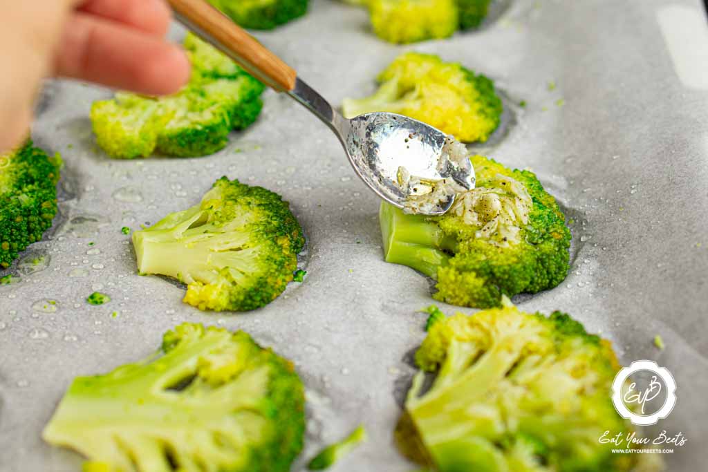 Coating broccoli pieces with oil and lemon juice mixture.