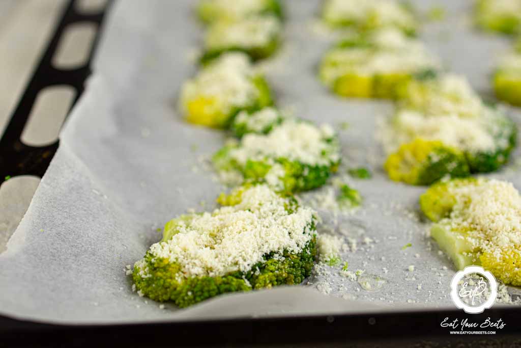 Parmesan drizzled over broccoli pieces.