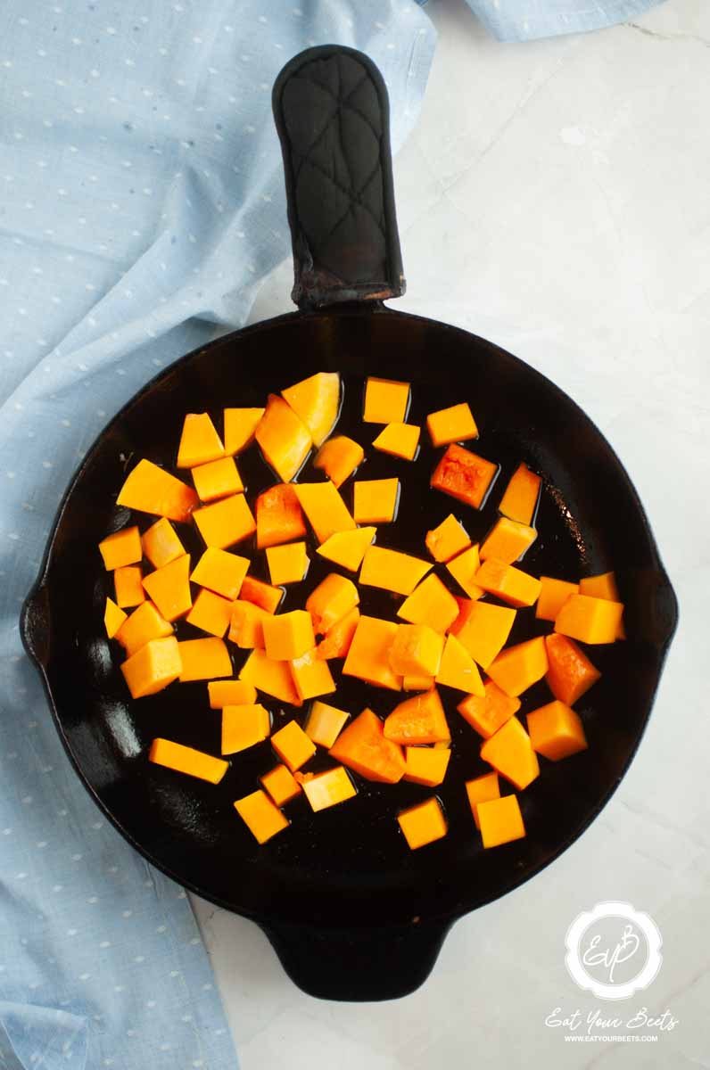 Butternut squash cubes in a skillets.