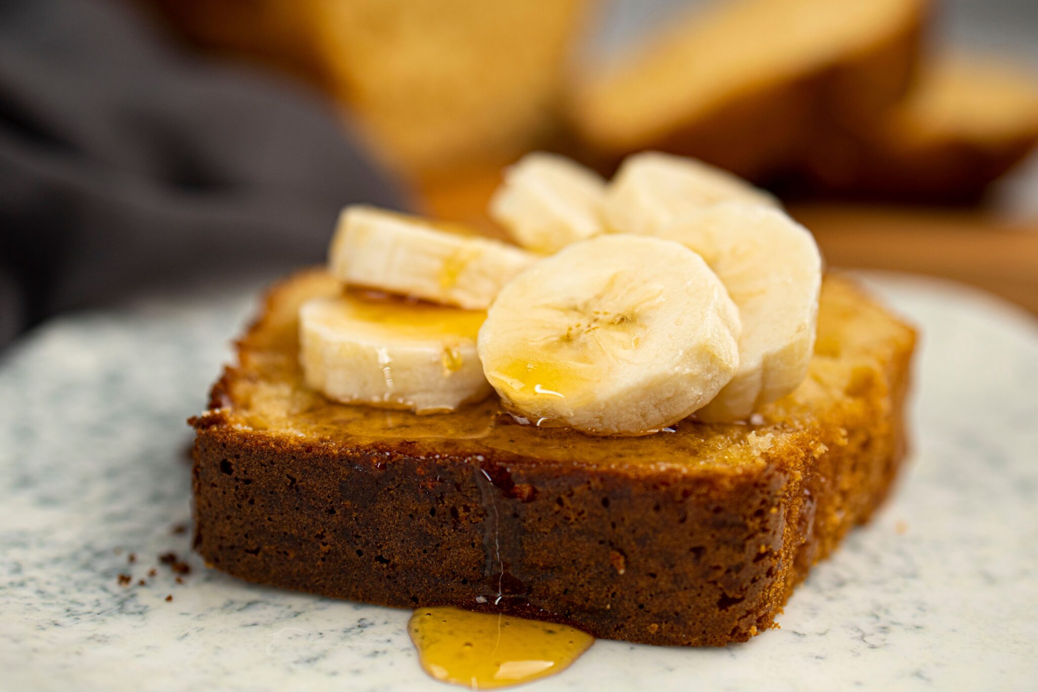protein cake with banana and maple syrup on a plate.
