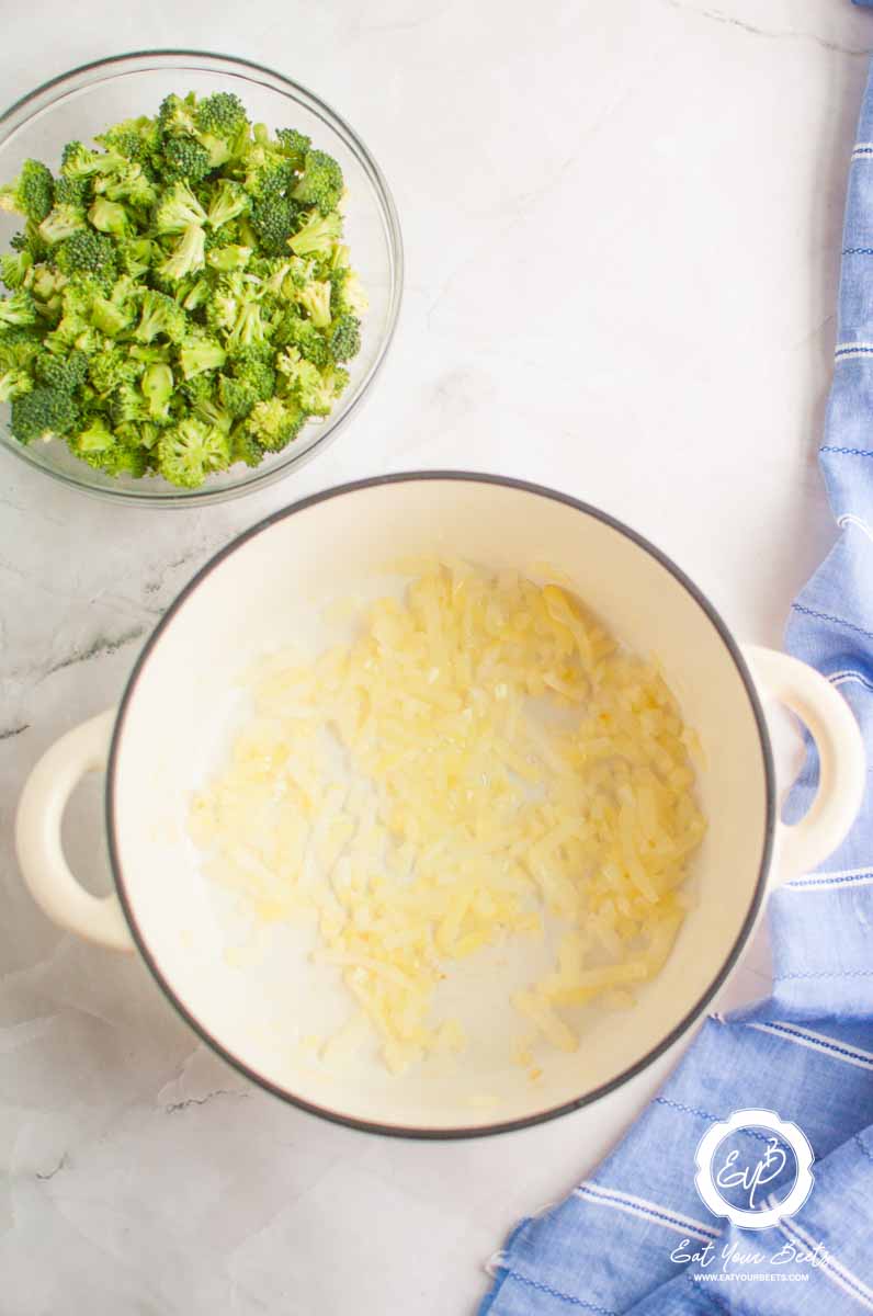Broccoli in a bowl and onion in a pan in a pot.