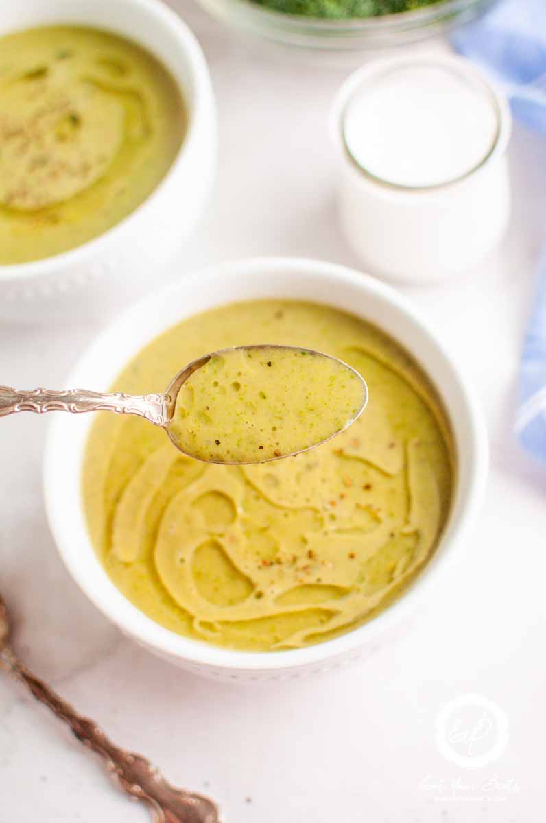 Creamy broccoli soup in a bowl and on a spoon.