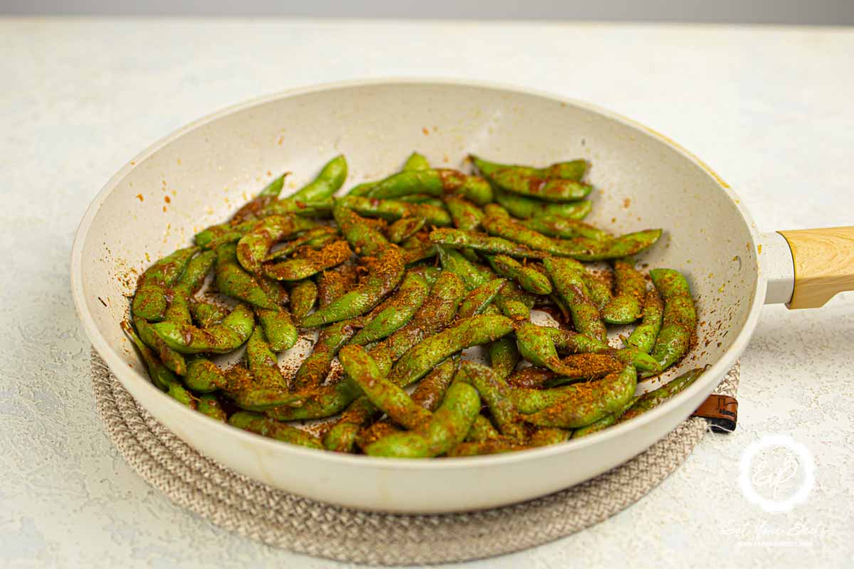 Cooking edamame in a frying pan.