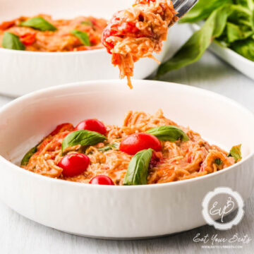 einkorn angel hair and cherry tomato pasta in a white bowl.